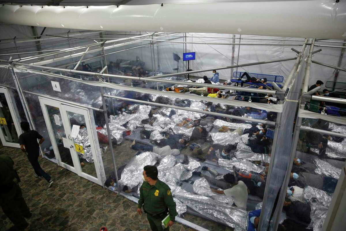 FILE - In this March 30, 2021, file photo, young minors lie inside a pod at the Donna Department of Homeland Security holding facility, the main detention center for unaccompanied children in the Rio Grande Valley run by U.S. Customs and Border Protection (CBP), in Donna, Texas. Migrant families will be held at hotels in the Phoenix area in response to a growing number of people crossing the U.S.-Mexico border, authorities said Friday, April 9, 2021 another step in the Biden administration's rush to set up temporary space for them. (AP Photo/Dario Lopez-Mills, Pool, File)