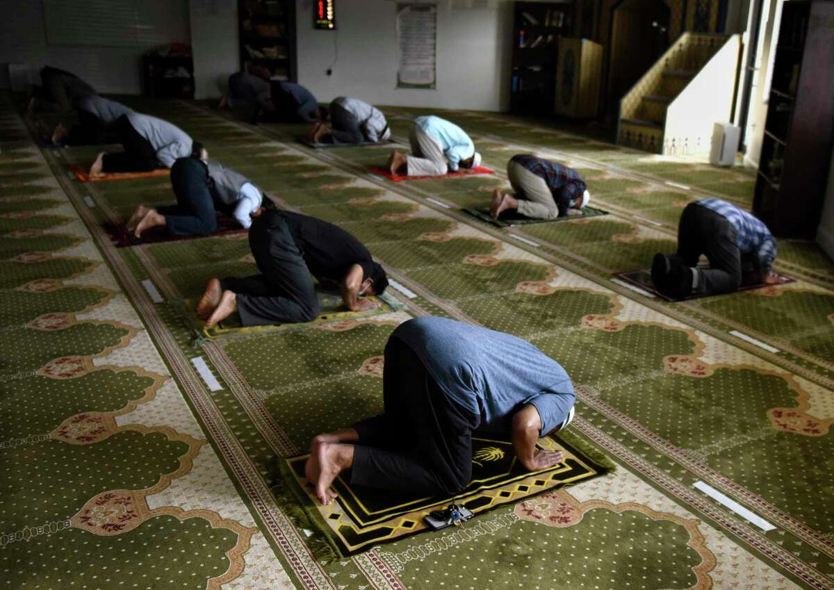 Worshippers bow in prayer at the early-afternoon jamaat during the holy month of Ramadan at Stamford Islamic Center in Stamford, Conn. Wednesday, April 14, 2021. The mosque was closed due to COVID last year during Ramadan, but is open this year with safety precautions in place. Capacity has been limited from 130 to 55 and worshippers are expected to bring their own prayer mats, wear masks, and stay six feet apart from one another.