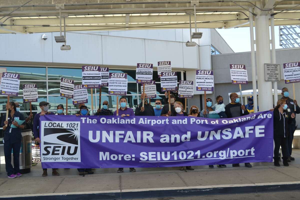Custodians protest outside the Southwest terminal at Oakland International Airport on Wednesday, April 14, 2021.
