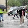 A crossing guard assists Pietzch-MacArthur students as they cross Highland Avenue in a late afternoon rainfall Wednesday. Photo made Wednesday, April 14, 2021 Kim Brent/The Enterprise