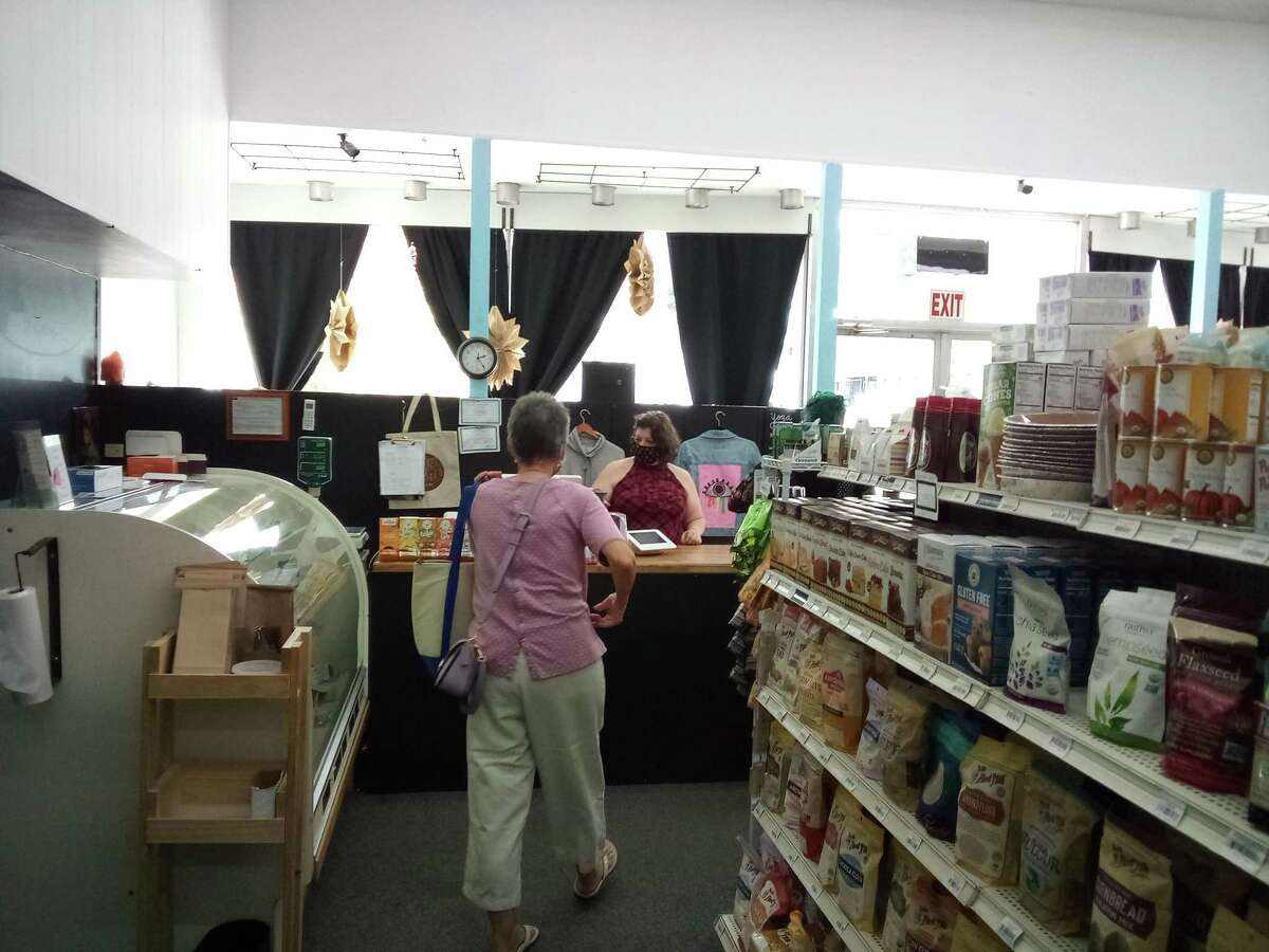 Rooted Market Manager Nicole Starr waits on a customer at the counter.