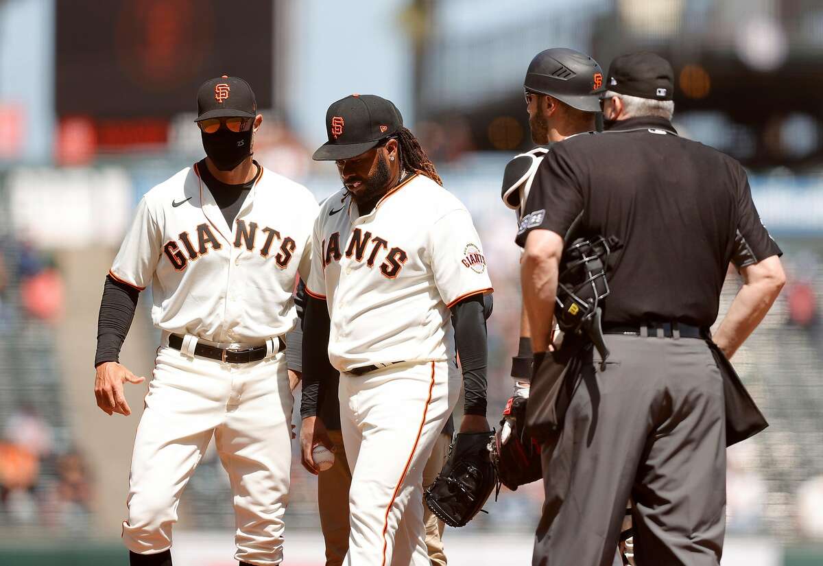 Johnny Cueto (center) removes himself in the sixth inning, with help from Gabe Kapler, after experiencing tightness.