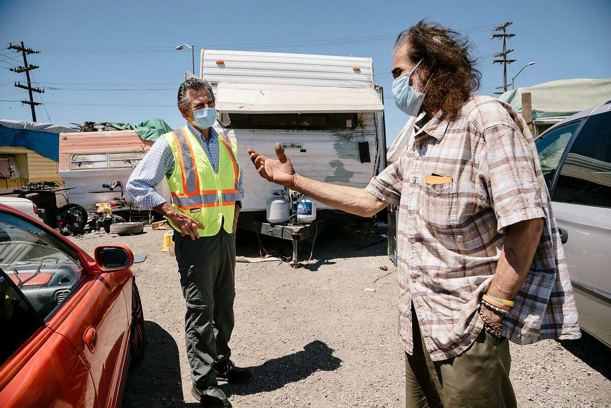 Oakland City Council Member Noel Gallo talks with Gilberto Gonzales at the High Street homeless encampment.
