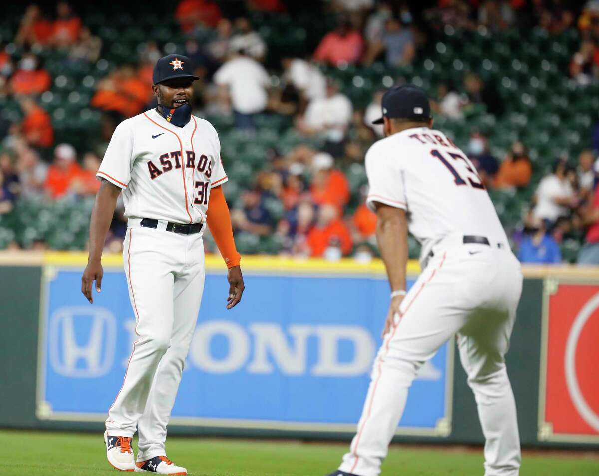 Houston Astros designated hitter Ronnie Dawson (31) and Abraham Toro (13) warm up before the first inning of an MLB baseball game at Minute Maid Park, in Houston, Wednesday, April 14, 2021.