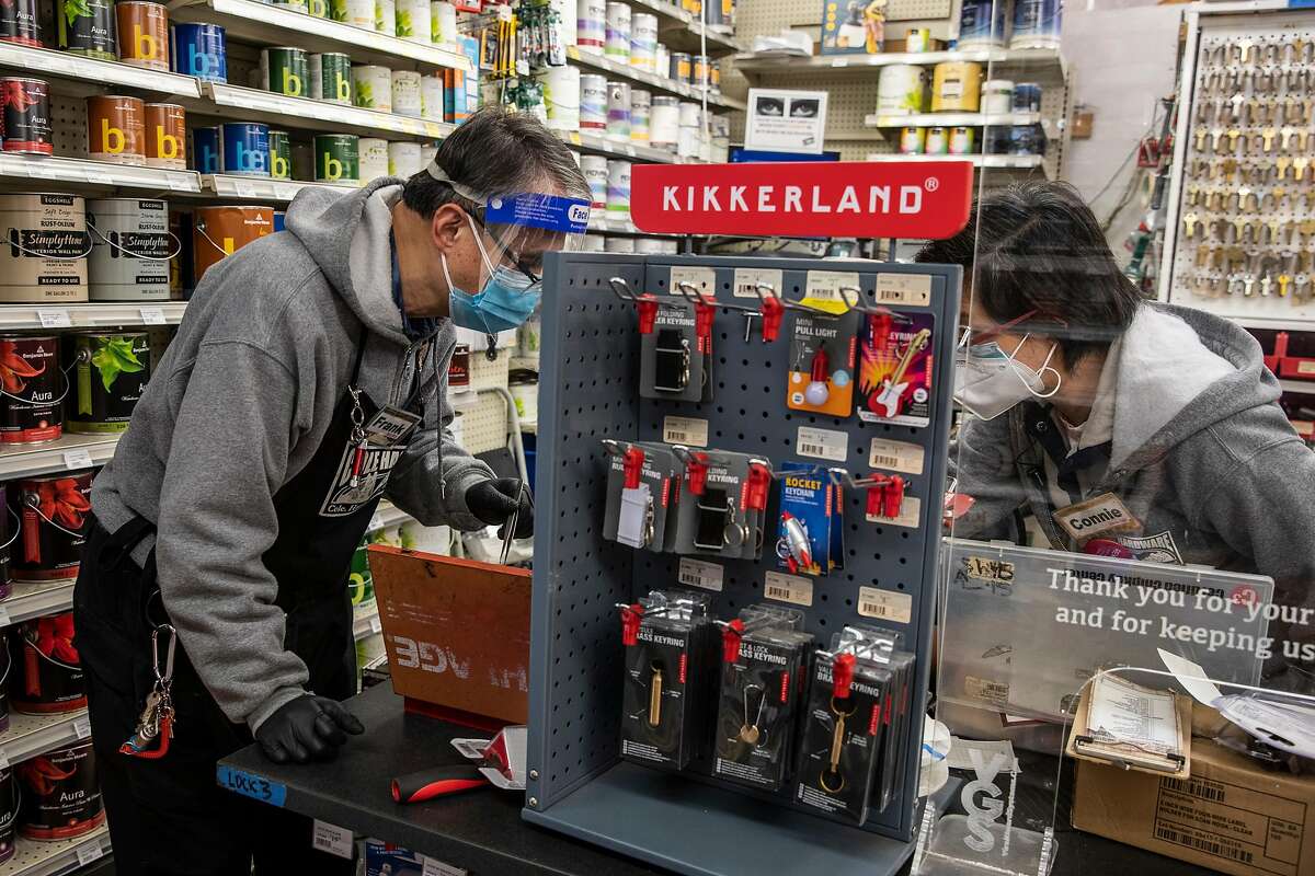 (L-R) Master Locksmith Frank Yee, Joseph Mondejar and Assistant Manager Connie Zhang look for a part while rekeying a lock at Cole Hardware in Downtown San Francisco, California Wednesday, April 14, 2021.