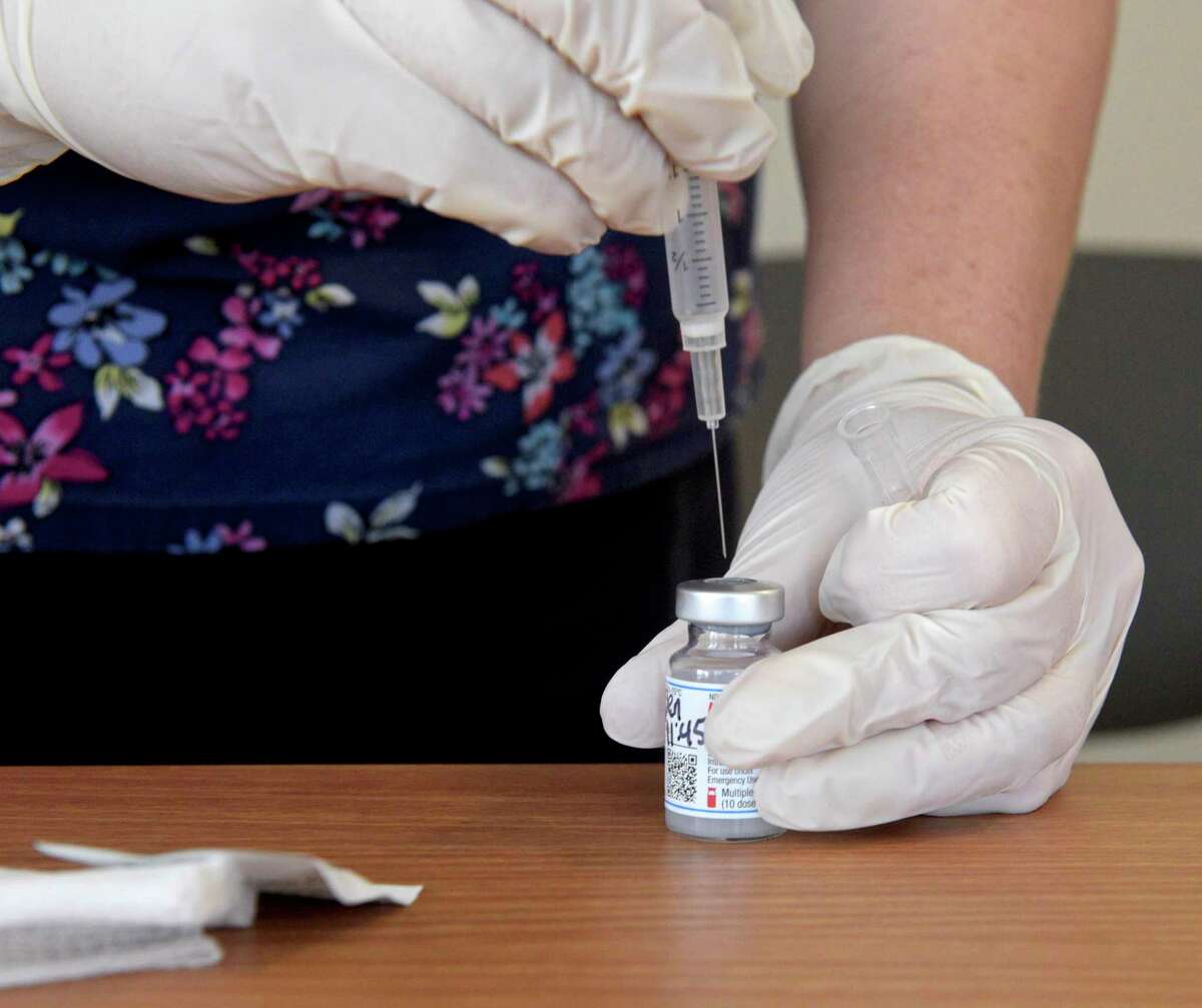 Alysa Irizarry, RN, from the Connecticut Institute for Communities’ Greater Danbury Community Health Center, prepares a COVID vaccination on Monday afternoon. December 4, 2021, in Danbury, Conn.