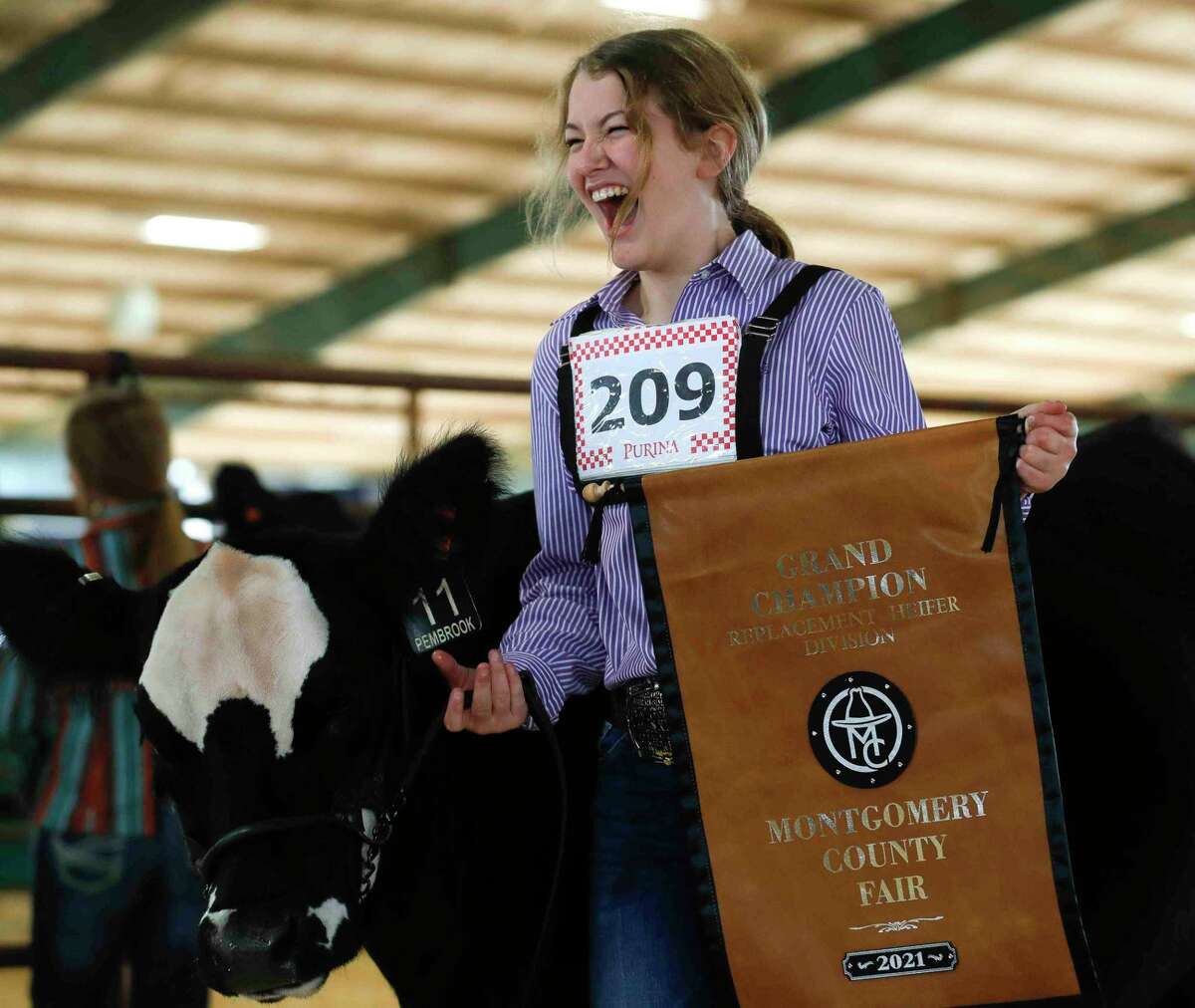 Zoe Romanchuk of Montgomery Dobbin 4-H reacts after her heifer, Trixie Pixie, won grand champion during the replacement heifer show at the Montgomery County Fair & Rodeo, Thursday, April 15, 2021, in Conroe. This year’s fair kicks off Friday.
