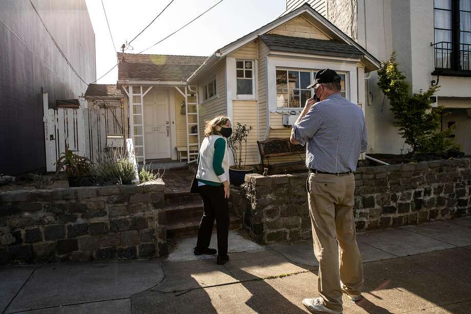 San Francisco natives Marsha and Bryan Britt stand on the sidewalk as they visit 1227 24th Avenue, a San Francisco City Landmark and a home made up of three Type A and one Type B 1906 earthquake refugee cottages after reading about its existence in San Francisco, California Wednesday, April 14, 2021. Photo: Stephen Lam / The Chronicle