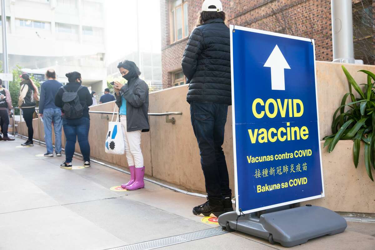 People outside Zuckerberg San Francisco General Hospital stand in a walk-up line to receive the COVID-19 vaccine in San Francisco on April 15, 2021.