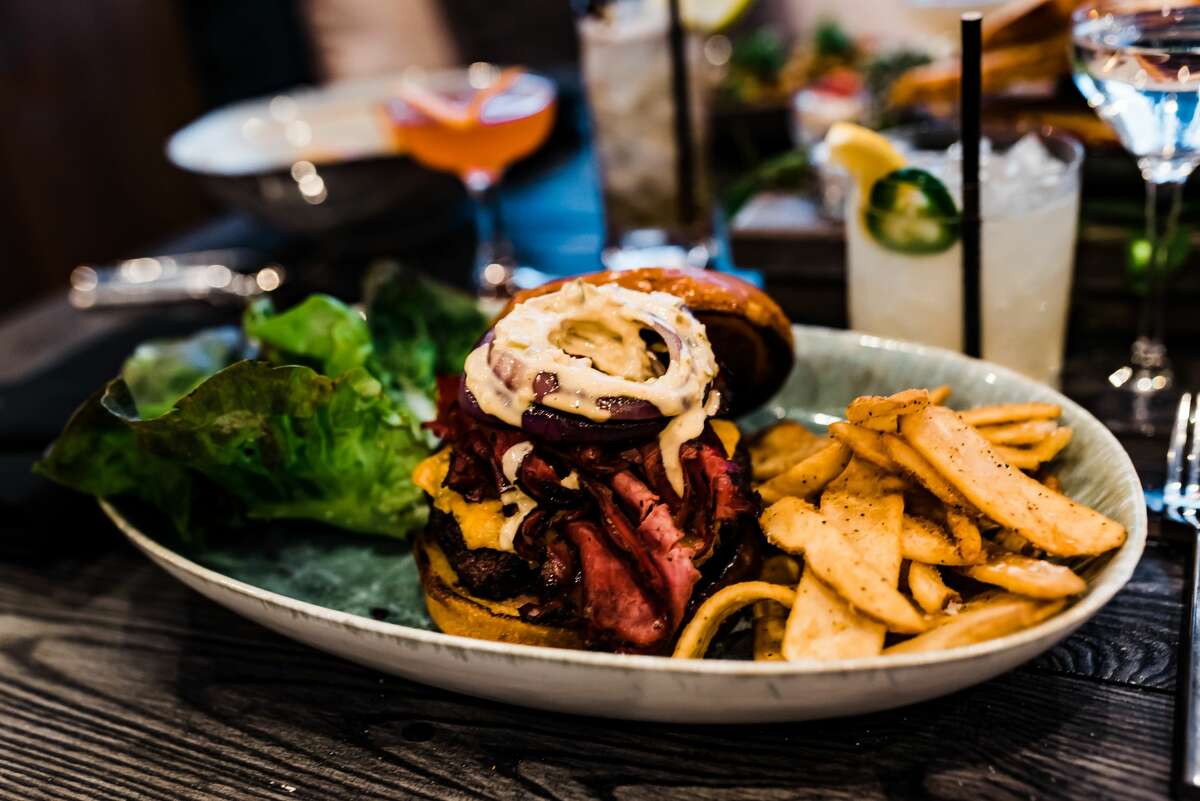 The Tavern Burger: a Wagyu patty with white cheddar, black garlic truffle aioli, grilled onions and smoked tomato chutney.