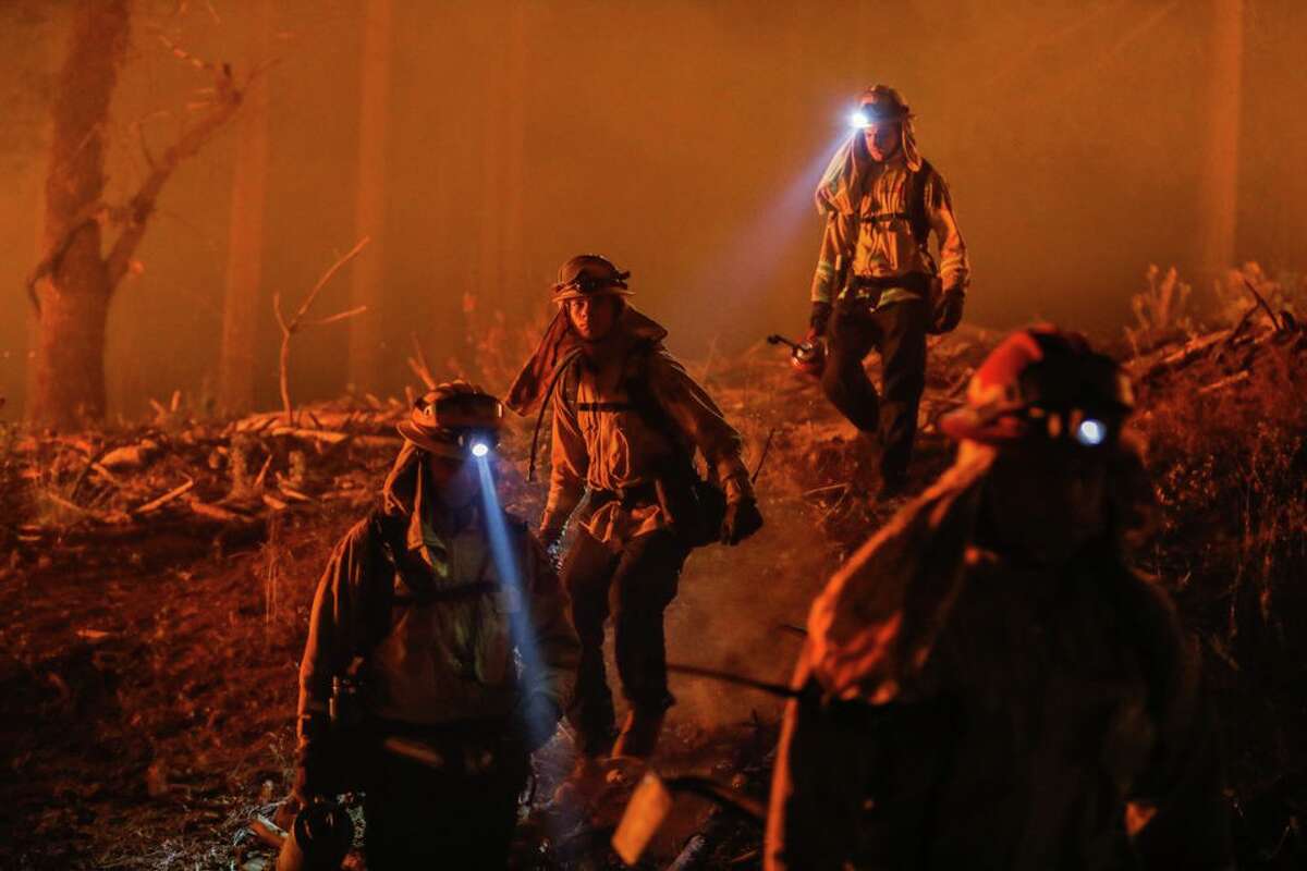 Firefighters walk through brush as they prepare for a backburn operation on the North Complex in Butte County in September 2020. Scientists argue that climate change is one of the main causes of major wildfire events and will continue to worsen as temperatures rise.