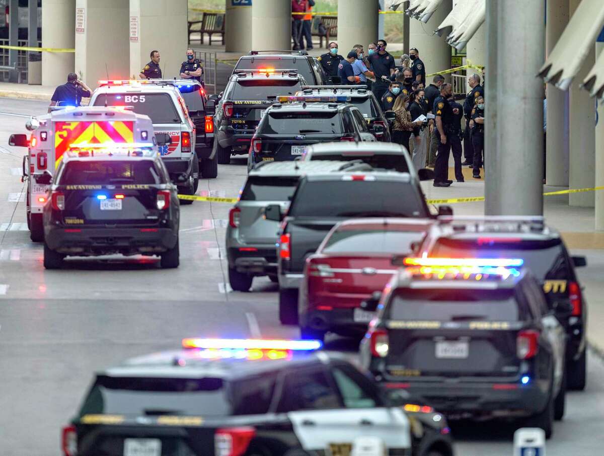 Des dizaines de véhicules de police et d'urgence sont aperçus le jeudi 15 avril 2021 à l'aéroport international de San Antonio après qu'un officier a tiré sur les voies de prise en charge des passagers au niveau inférieur.  Les terminaux de l'aéroport ont été évacués et sécurisés par des portes aux points de contrôle de la TSA par mesure de précaution, selon la police.