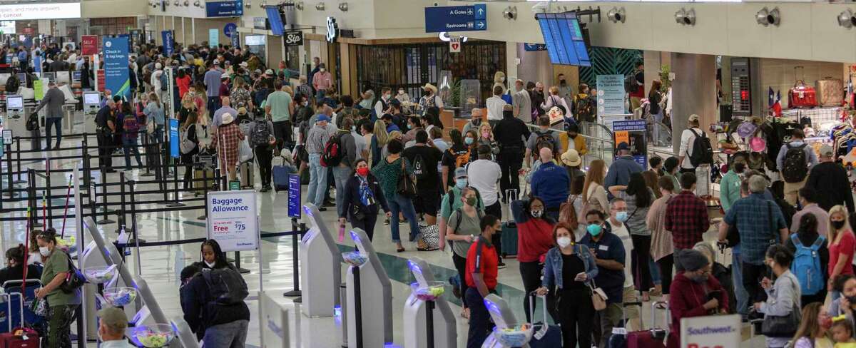 Les passagers font la queue jeudi 15 avril 2021 dans le terminal A de l'aéroport international de San Antonio pour que les points de contrôle TSA rouvrent après l'évacuation des terminaux en raison d'un agent impliqué en tirant à l'extérieur du terminal dans la zone de prise en charge des passagers du niveau inférieur.  La ligne au moment où la photo a été prise s'étendait tout au long des terminaux A et B, sur le trottoir et sur toute la longueur des deux terminaux.