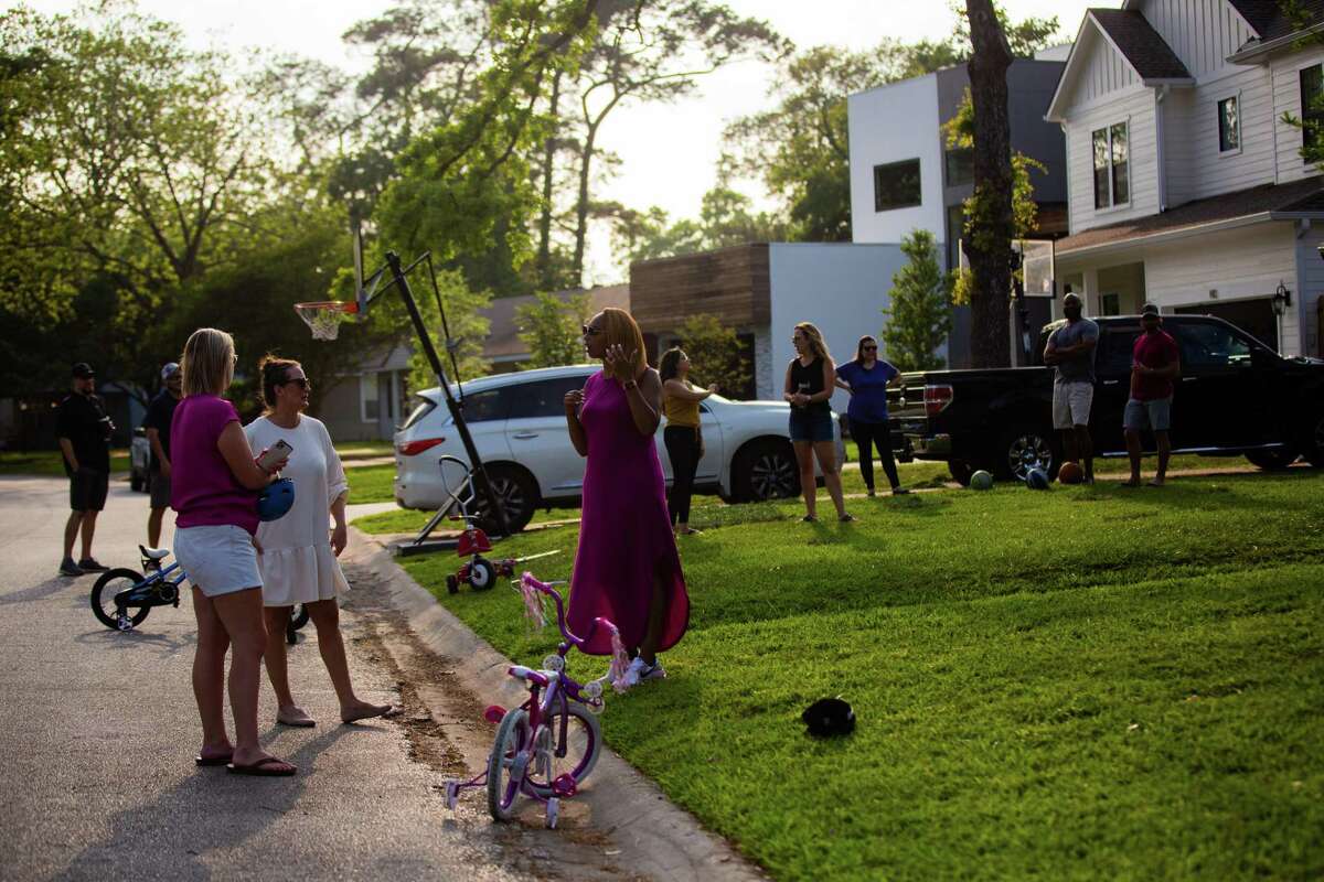 Oak Forest neighbors enjoy the afternoon together at their street, Monday, April 12, 2021, in Houston.