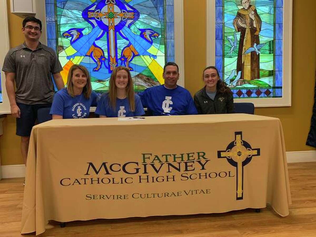 Father McGivney senior Anna McKee, seated third from right, will play college basketball for Illinois College in Jacksonville. She is joined in the picture by her family and coach Jeff Oller.
