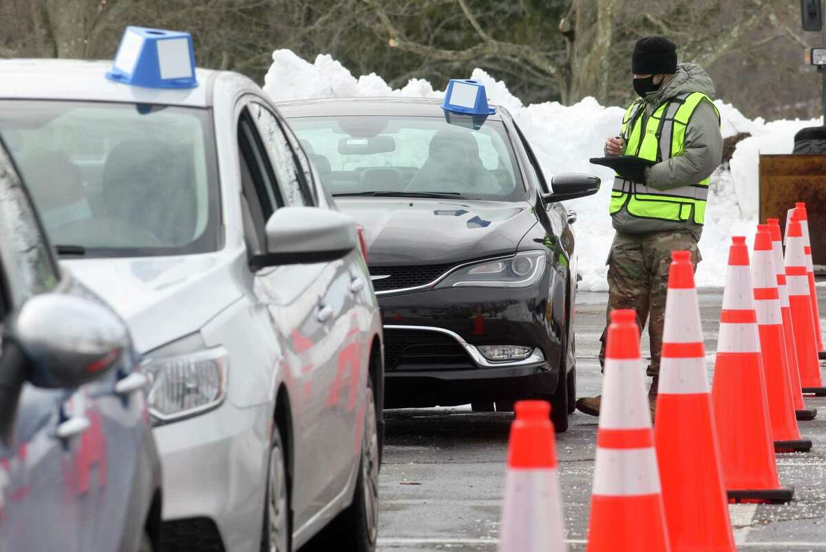 A member of the Connecticut National Guard checks in patients before they receive the Pfizer vaccince shot during Community Health Center's mass drive-through COVID-19 vaccination clinic held at the parking lot of Lord & Taylor in Stamford, Conn., on Wednesday Feb. 3, 2021. The town of Darien and Darien schools have partnered with the CHC to hold a clinic for Darien seniors on May 1 and May 22.