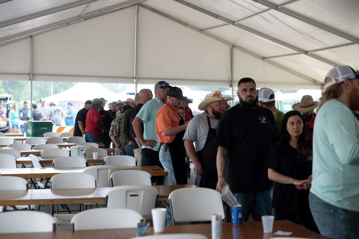 Participants of the Midnight Love Street BBQ Cookoff line up to collect their competition plates at the Montgomery County Fair & Rodeo, Friday, April 16, 2021, in Conroe. An estimated 110 teams competed in this year's cookoff.