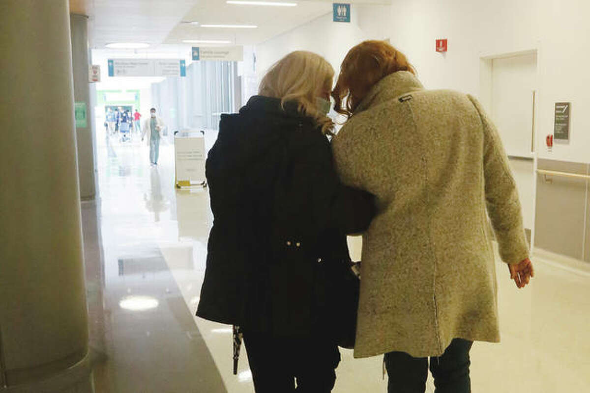 Janine Blezien (left) and Dianne Green walk arm-in-arm at Rush University Medical Center in Chicago during their first in-person meeting. Blezien, a nurse at Rush, and Green, a retiree, met by phone the previous year through the hospital’s “friendly caller” program for which Blezien is a volunteer. They were able to get together after being vaccinated against COVID-19, and they plan to go out to a restaurant and shop together, once they both feel safe doing so.