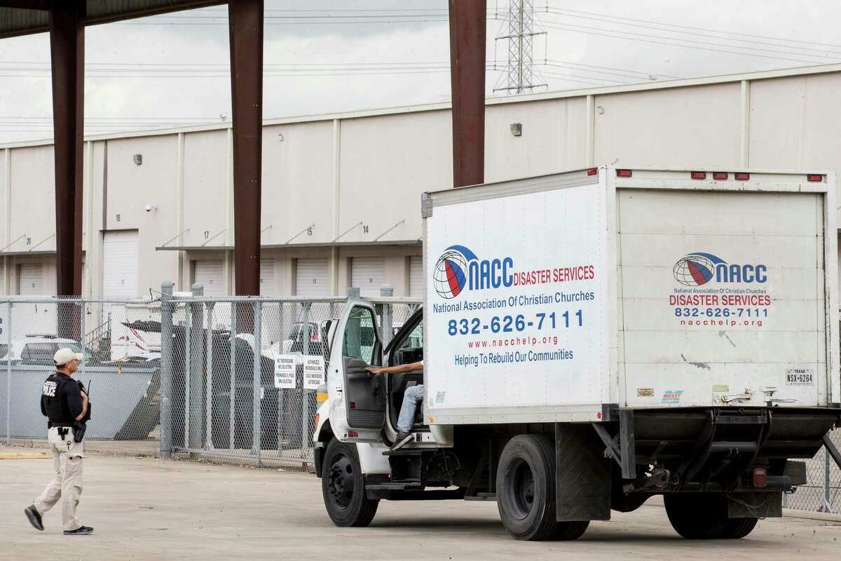 A U.S. Department of Homeland Security officer checks on a truck driver outside the National Association of Christian Churches facility, before allowing access to the facility where hundreds of migrant girls are being housed Monday, April 5, 2021 in Houston.