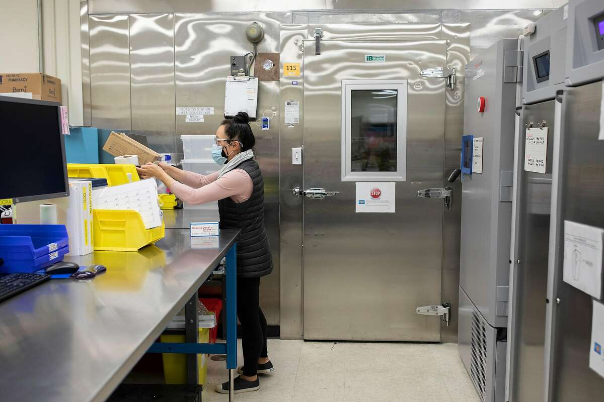 An S.F. General Hospital pharmacist next to the freezer that holds COVID-19 vaccine that came from Humboldt County.