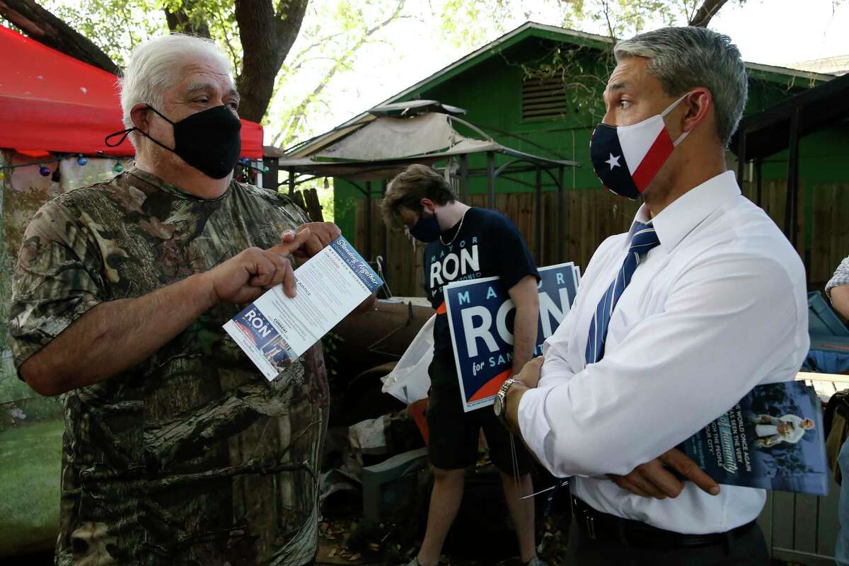 San Antonio Mayor Ron Nirenberg visits with former Army Ranger Victor M. Bosquez, 72, as he campaigns door to door in the city’s southwest side, Wednesday, April 7, 2021. Nirenberg is seeking reelection in the May 1 General Election. There are 14 candidates, including Nirenberg, on the ballot. Behind is campaign field organizer, Austin Dolan, 23.