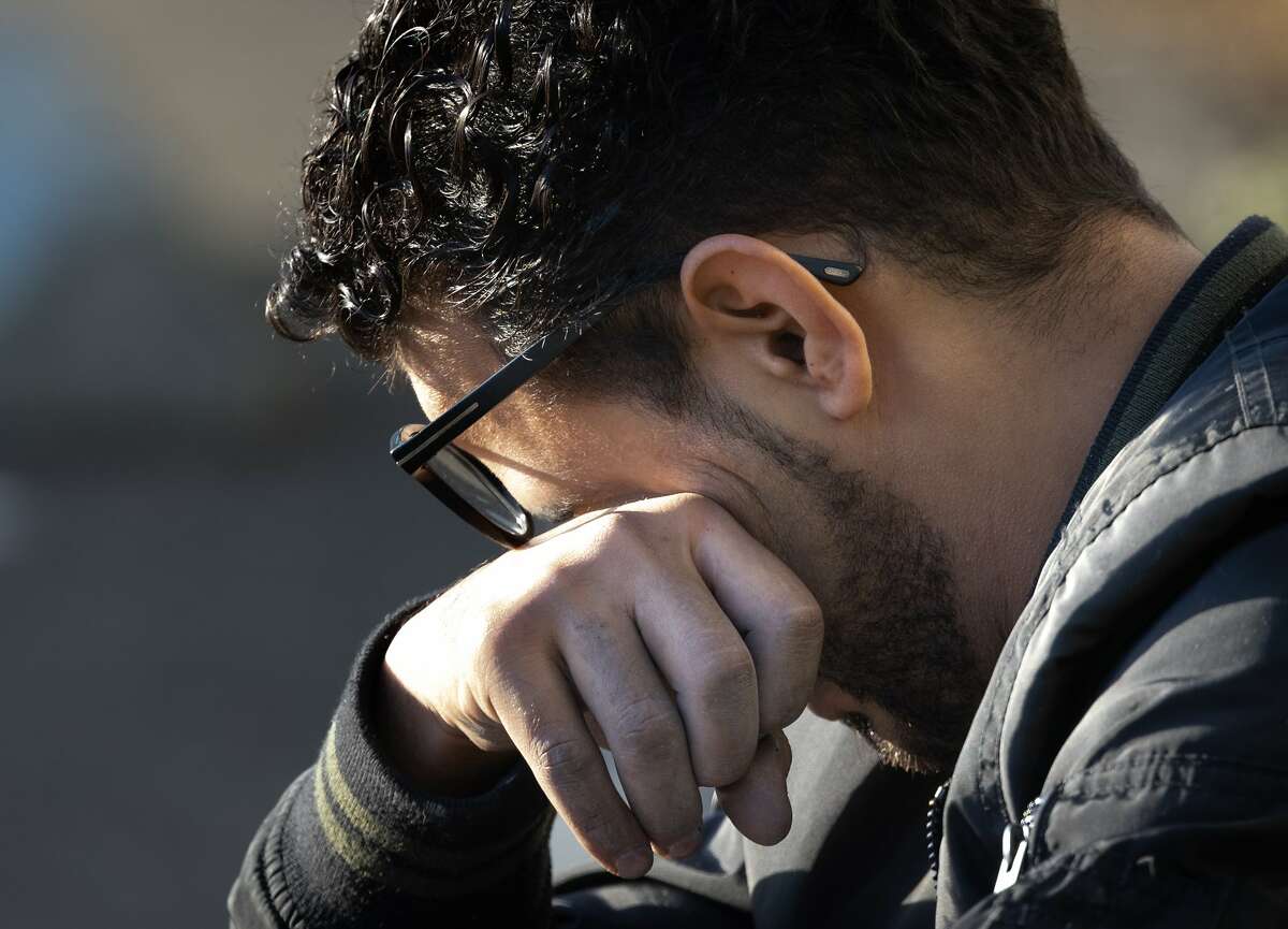 Muneer Paphthan, a cousin of the man who died, cries across the street from the Oakland house fire.