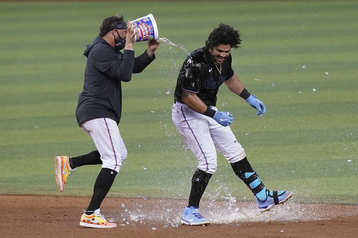 The Marlins’ Miguel Rojas pours a bucket of water on Jorge Alfaro after Alfaro hit a double to drive in the winning run.