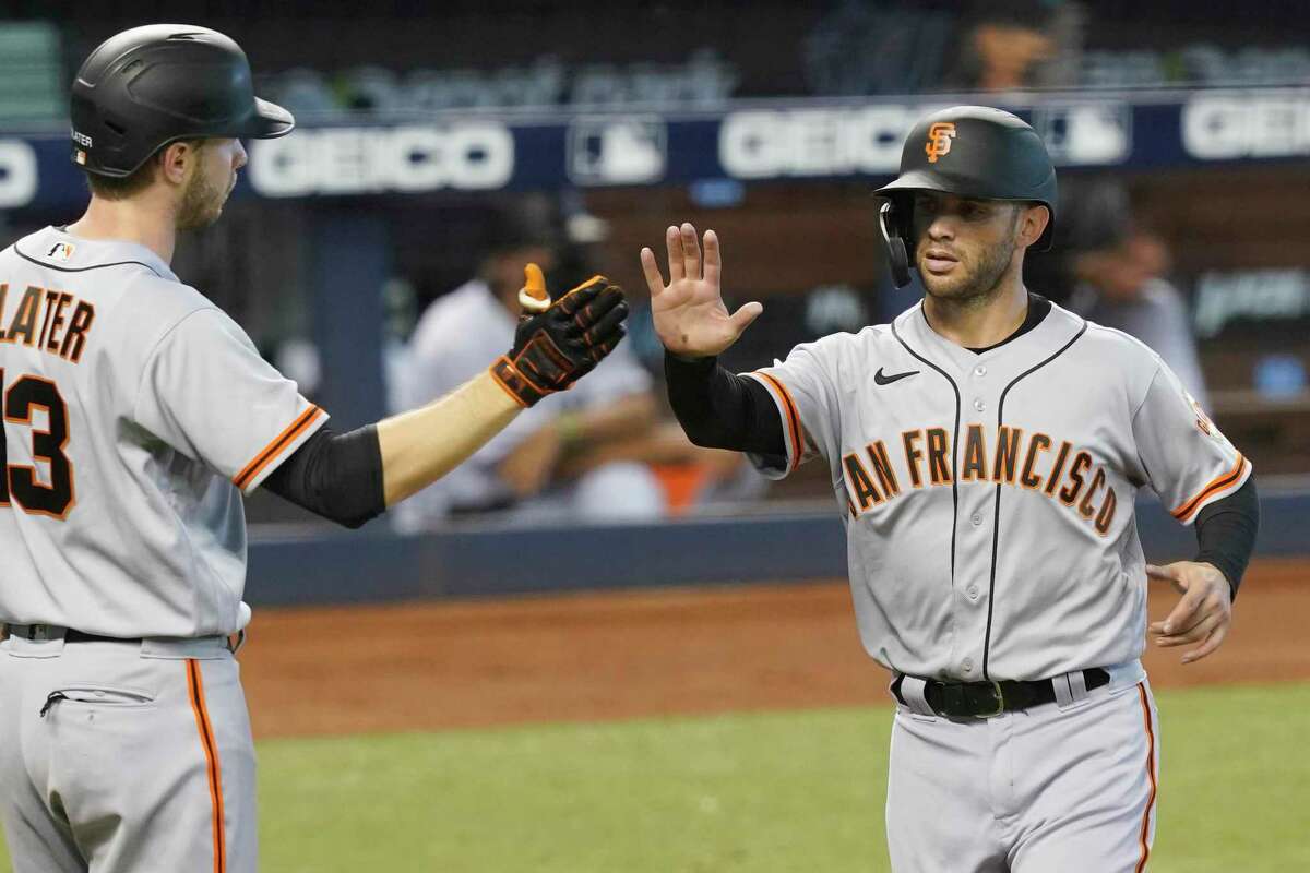 San Francisco Giants' Austin Slater (13) congratulates Tommy La Stella after he scores a run in the third inning of a baseball game against the Miami Marlins, Sunday, April 18, 2021, in Miami.