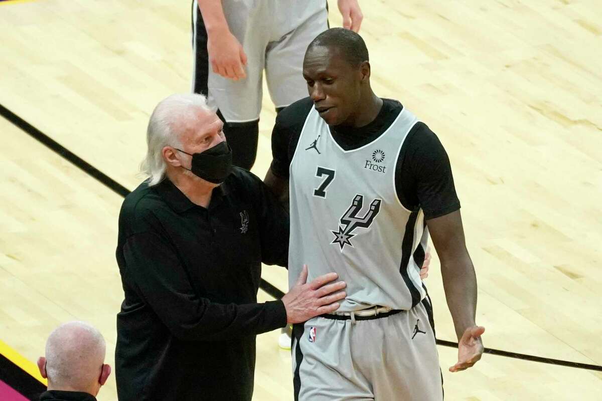 San Antonio Spurs center Gorgui Dieng (7) talks to coach Gregg Popovich after being ejected during the second half of the team's NBA basketball game against the Phoenix Suns, Saturday, April 17, 2021, in Phoenix. (AP Photo/Rick Scuteri)
