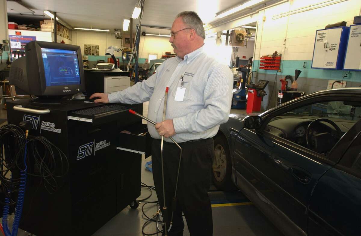 North Haven, Connecticut-10/17/03: Local auto repair shop ownerDave Bouchard, of Bouchard Automotive, works with a computer to run a new State of Connecticut emissions testing program in his garage. The program, implemented and managed by Agbar Technologies, Inc., incorporates a network of local auto repair garage statewide and tauts itself as the most sophisticated emissions testing program in the United States. ©2003 Peter Hvizdak ph0145a #4168