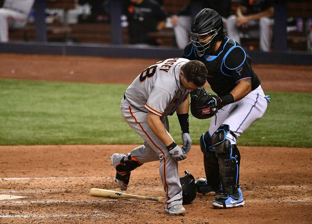 The Giants’ Buster Posey is hit by a pitch from Sandy Alcantara of the Miami Marlins in the seventh inning at loanDepot on Saturday.