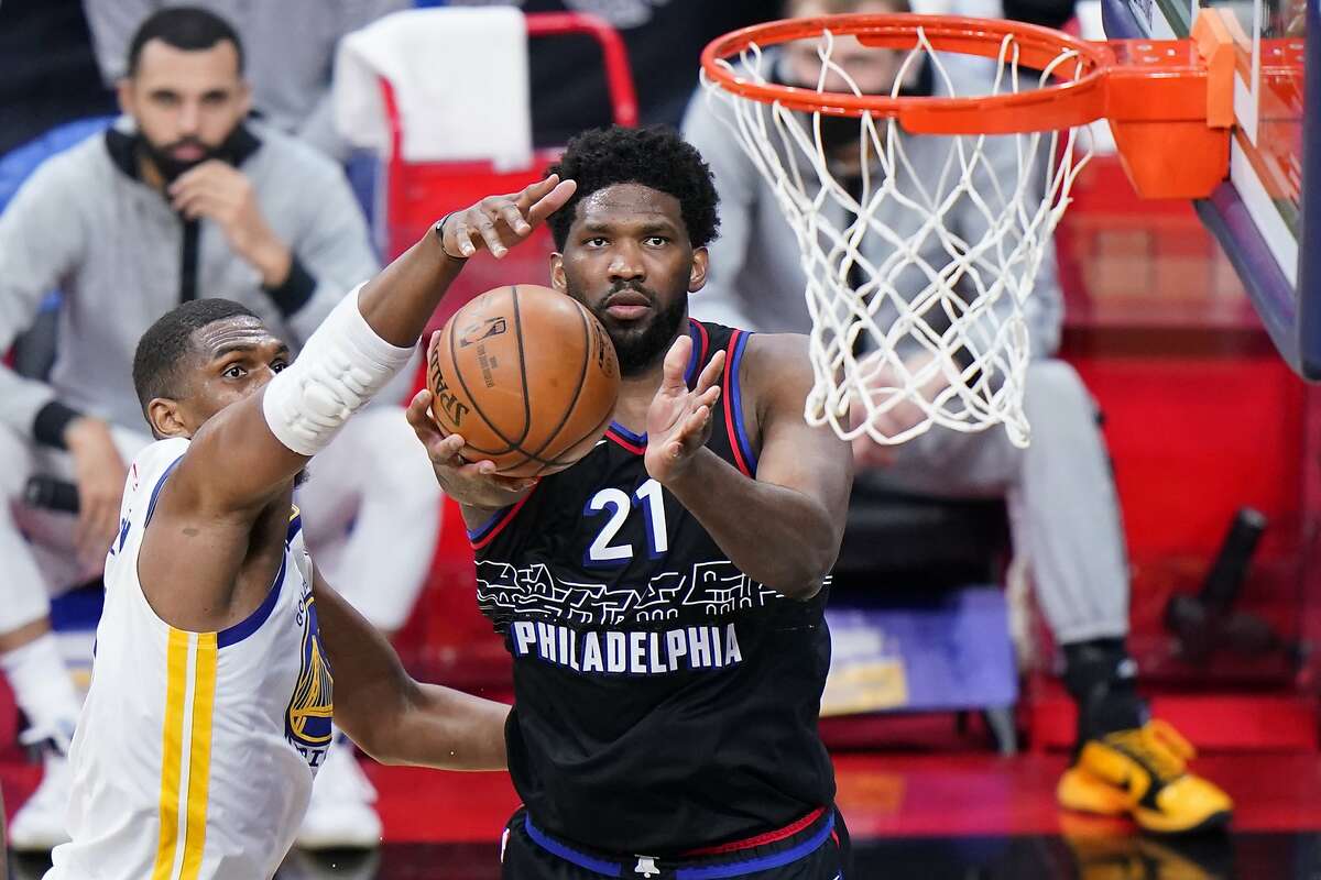 Philadelphia 76ers' Joel Embiid, right, goes up for a shot against Golden State Warriors' Kevon Looney during the second half of an NBA basketball game, Monday, April 19, 2021, in Philadelphia. (AP Photo/Matt Slocum)