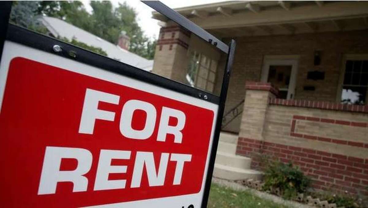 FILE - A photo of a For Rent sign in front of a home