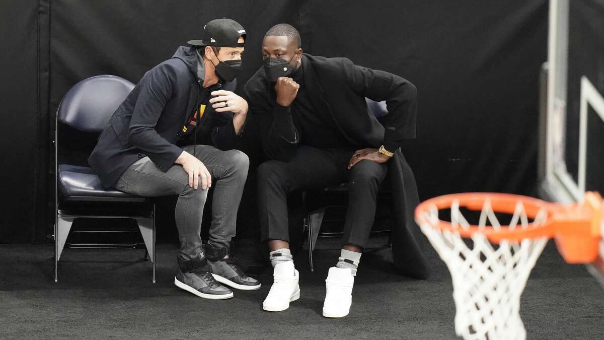 Ryan Smith, left, and Dwyane Wade, right, speak in the first half during an NBA basketball game between the Indiana Pacers and Utah Jazz Friday, April 16, 2021, in Salt Lake City.