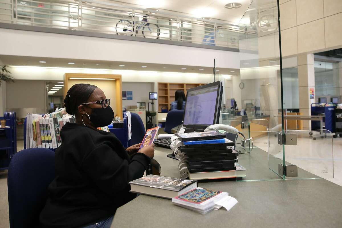 Linda Greenfield, a library assistant in S.F., processes materials that were on hold for pickup.
