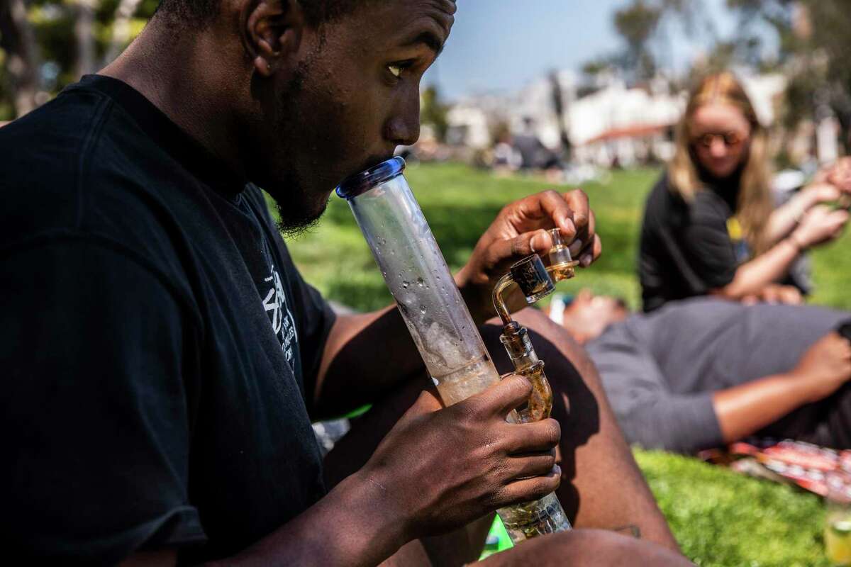 Maximilian Soares prepares to smoke marijuana from a water bong during the annual observance of 4/20 for cannabis consumption in San Francisco, California Tuesday, April 20, 2021.