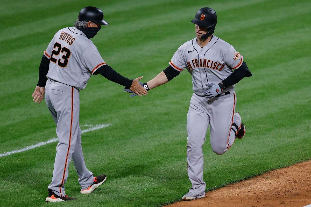 The Giants’ Buster Posey celebrates with third base coach Ron Wotusthe in the fifth after hitting the first of his two home runs during the victory. Posey had three on the
