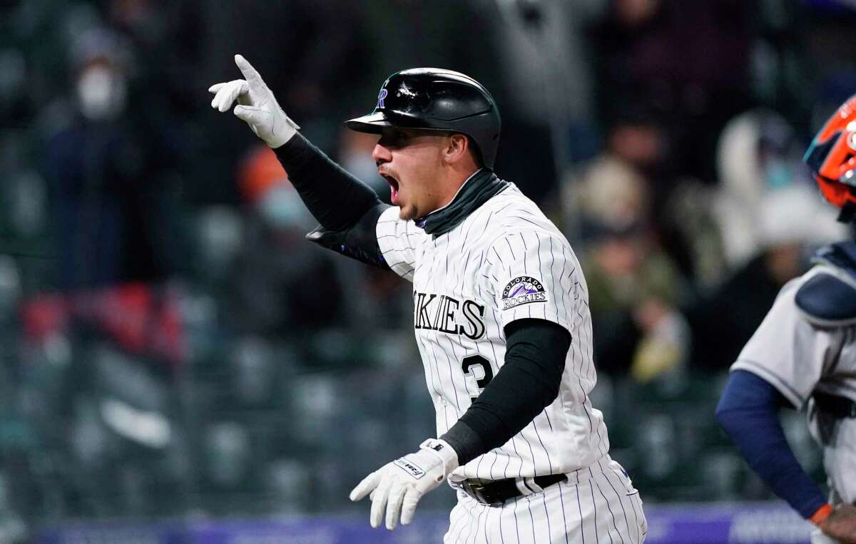 Colorado Rockies' Dom Nunez celebrates as crosses home plate after hitting a solo home run off Houston Astros relief pitcher Ryne Stanek during the seventh inning of a baseball game Tuesday, April 20, 2021, in Denver. (AP Photo/David Zalubowski)