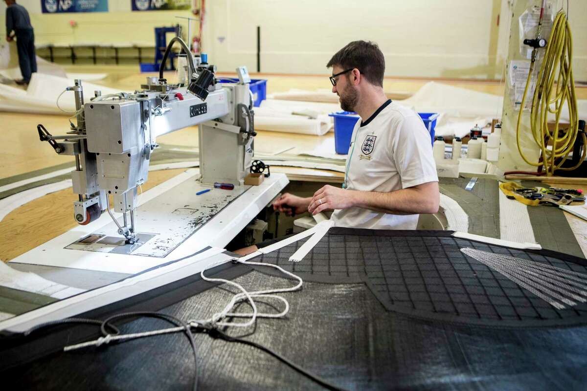 Brian Doyle sews tack webbing onto a sail that is 43 meters tall and 14 meters wide at North Sail in Milford.