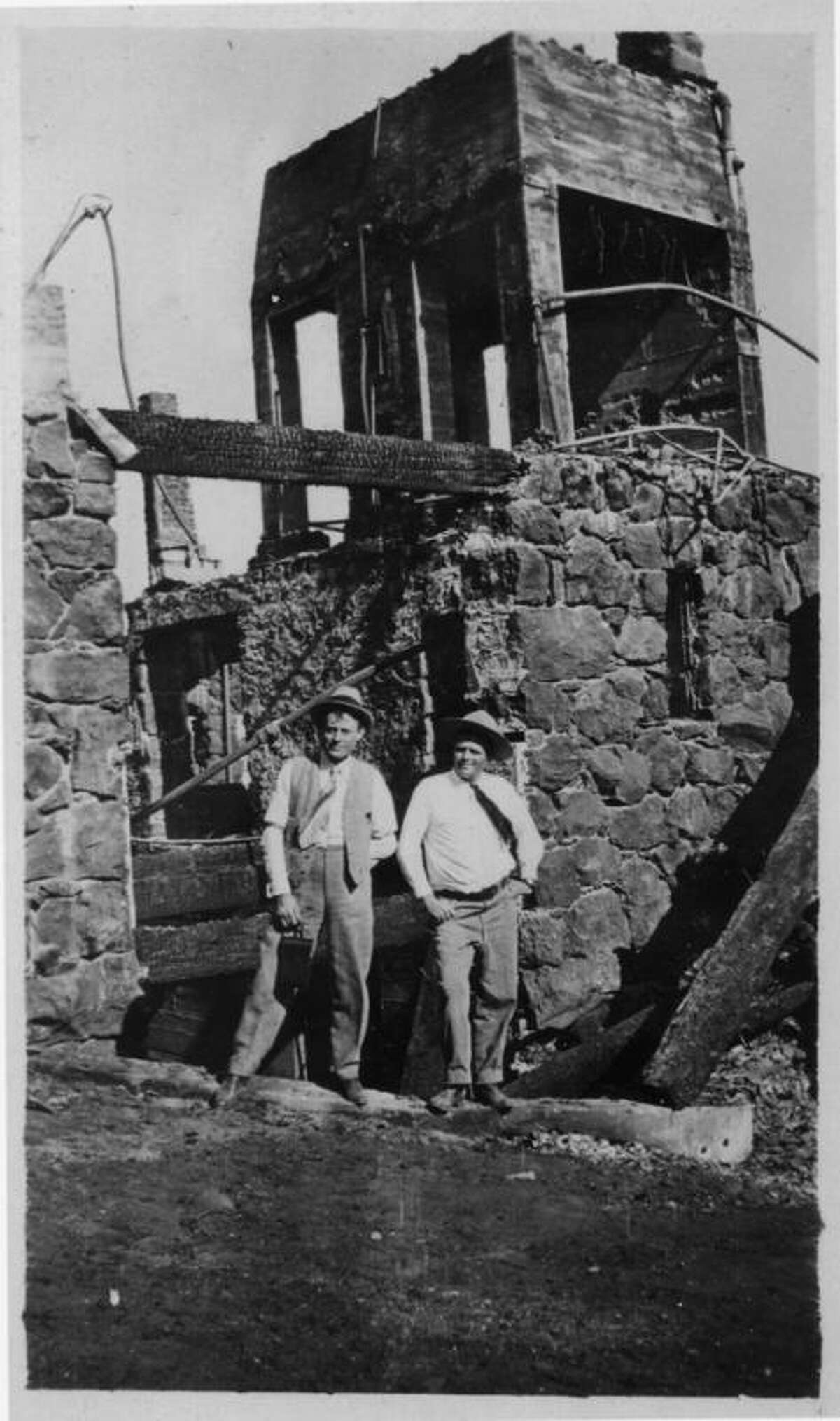 A historic photo shows Jack London (right) on site at Wolf House.