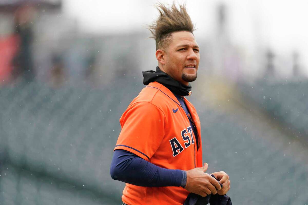 Houston Astros first baseman Yuli Gurriel waits for his hat and glove after flying out against Colorado Rockies starting pitcher Austin Gomber to end the top of the fourth inning of a baseball game Wednesday, April 21, 2021, in Denver. (AP Photo/David Zalubowski)