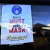 A sign informs patrons to wear masks during reopening at Brewport in Bridgeport May 19, 2020.