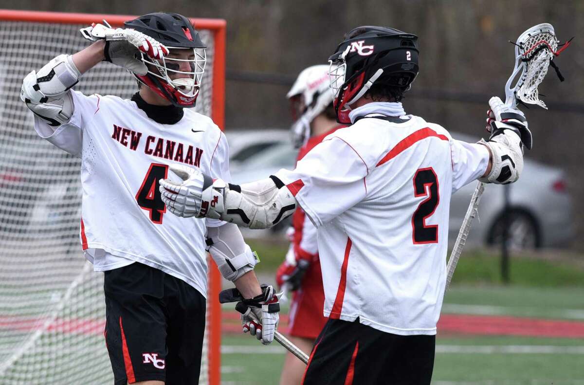 New Canaan’s Harry Appelt (4) and Chris Canet (2) celebrate a goal against Fairfield Prep at Dunning Field on Monday.
