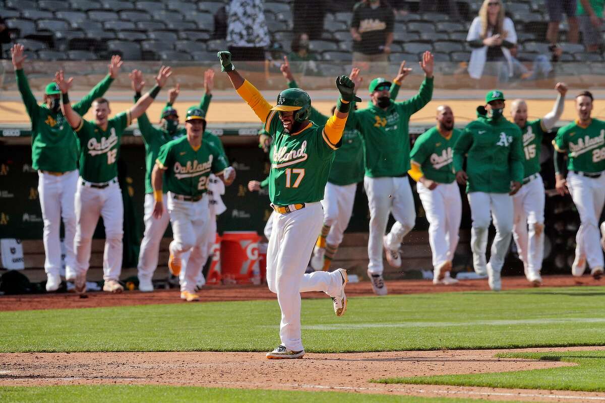 Elvis Andrus (17) runs toward home as the dugout empties out after Ramon Laureano (22) reached on a throwing error as the Oakland Athletics defeated the Minnesota Twins 13-12 in 10 innings at the Oakland Coliseum in Oakland, Calif., on Wednesday, April 21, 2021.