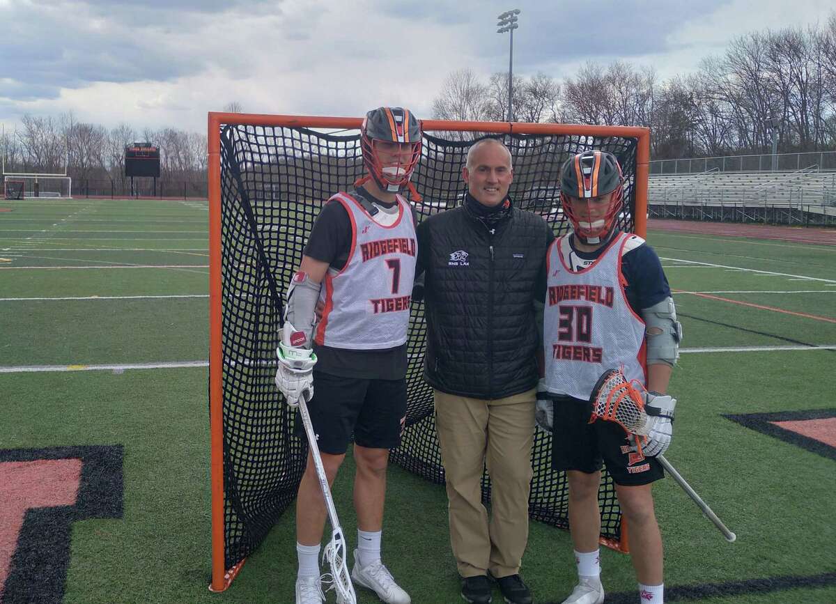 Junior Ryan Colsey, left, and freshman Kyle Colsey, right, flank their father and their coach at Ridgefield boys lacrosse, Roy Colsey, at Tiger Hollow in Ridgefield, Conn. Ryan and Kyle are attackmen for the Tigers.