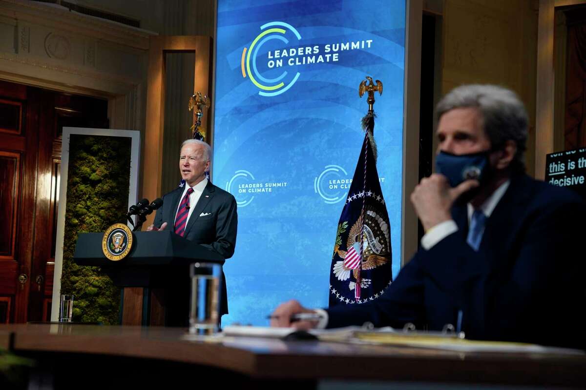 President Joe Biden speaks to the virtual Leaders Summit on Climate, from the East Room of the White House, Thursday, April 22, 2021, in Washington, as Special Presidential Envoy for Climate John Kerry, looks on.