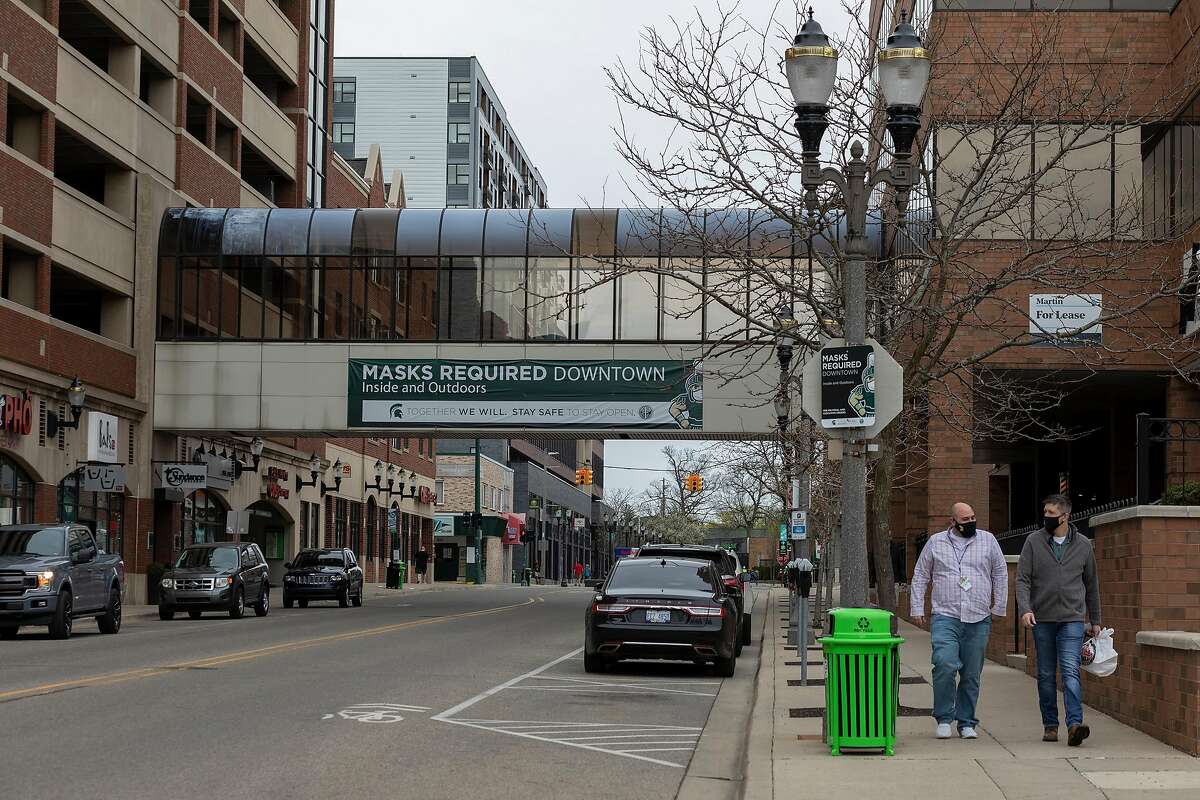 Signs remind residents of masking rules in East Lansing, Mich., on April 9, 2021. The state is home to nine of the 10 metro areas with the country’s highest recent case rates. (Elaine Cromie/The New York Times)