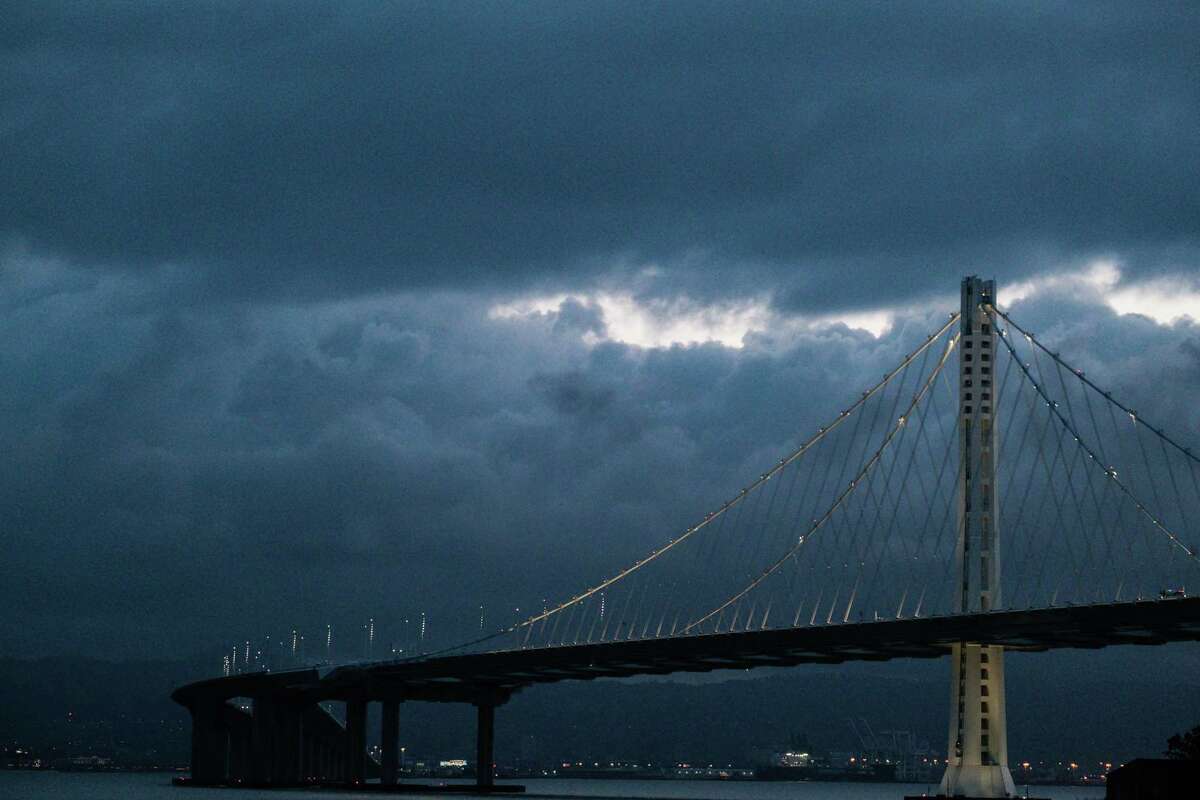 Large clouds loom over the eastern span of the Bay Bridge and the East Bay, as seen from Treasure Island in January 2021.