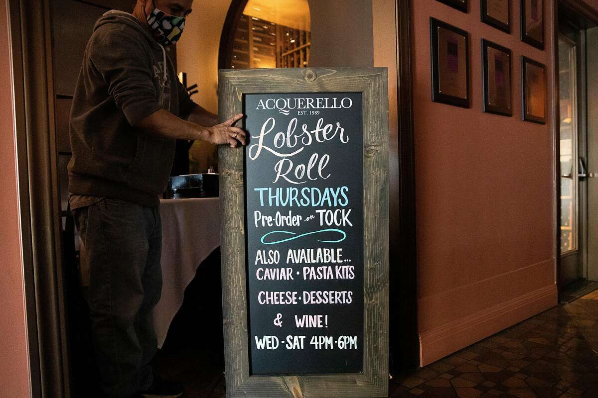 A sandwich board advertising takeout options sits in a small dining room currently being used for storage as San Francisco’s Acquerello restaurant prepares to welcome diners inside the restaurant in May.