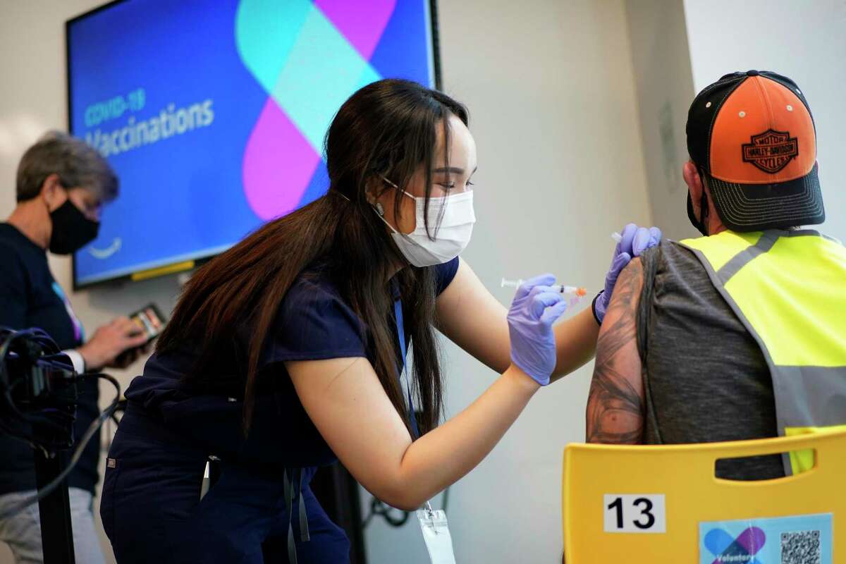 Registered nurse Sofia Mercado administers a shot at a vaccination event for workers at an Amazon fulfillment center. Amazon and some other large companies have hosted on-site inoculations, while smaller operations have helped book appointments for their workers.